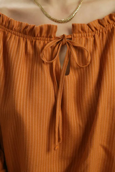 Çizgili turuncu bluzun yakın plan görüntüsü.