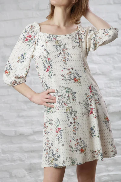 Çiçekli yaz elbisesi giymiş bir kadının stüdyo fotoğrafı..