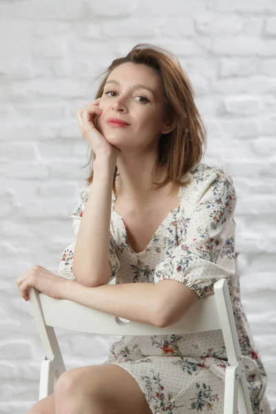 Çiçekli yaz elbisesi giymiş bir kadının stüdyo fotoğrafı..