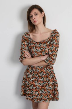 Çiçekli yaz elbisesi giymiş bir kadının stüdyo fotoğrafı..