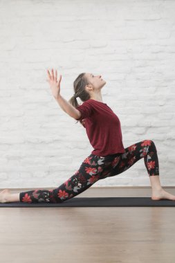 Yoga pozisyonlarını esneten genç bir kadın. Refah ve kendine bakım kavramı.