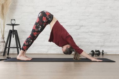 Yoga pozisyonlarını esneten genç bir kadın. Refah ve kendine bakım kavramı.
