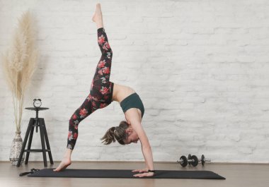 Yoga pozisyonlarını esneten genç bir kadın. Refah ve kendine bakım kavramı.