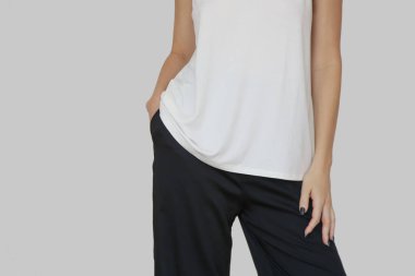 Beyaz pamuklu bluz ve siyah pantolon giyen bir kadın model. Klasik ve basit yaz modası. Stüdyo çekimi.