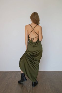 Stüdyo serisi. Uzun yeşil ipek elbiseli genç bir kadın.  