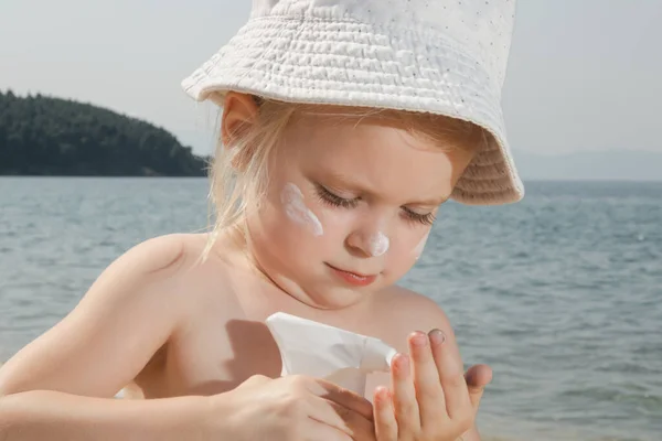 可爱的小女孩在海滩上涂防晒霜 在暑假期间用防晒乳液保护婴儿不晒太阳 旅行期间的儿童皮肤护理 — 图库照片