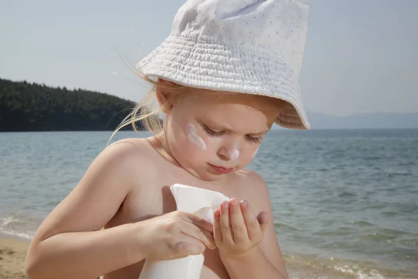 Carino Bambina Che Applica Crema Protettiva Sulla Spiaggia Lozione Solare — Foto Stock