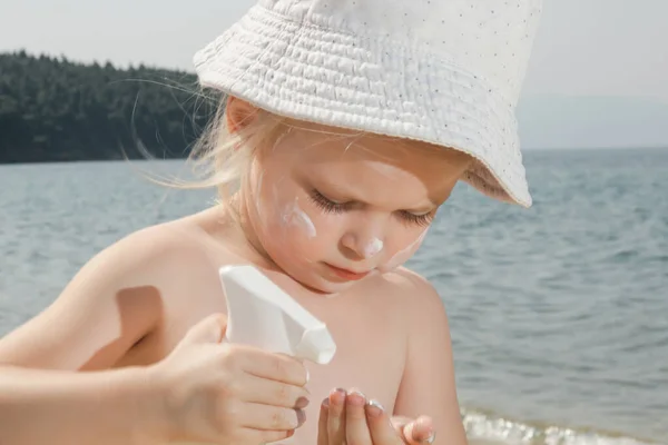 Carino Bambina Che Applica Crema Protettiva Sulla Spiaggia Lozione Solare — Foto Stock