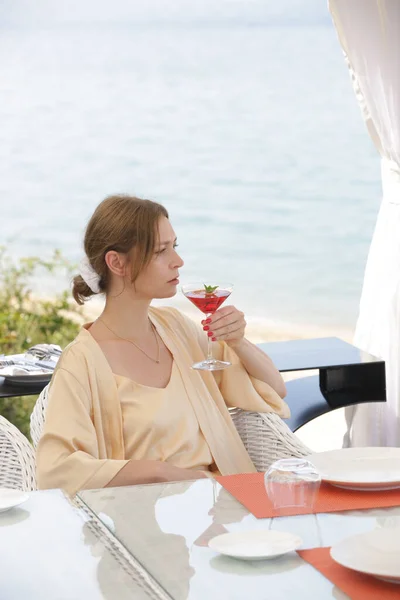 コスモポリタンカクテルのグラスを持ち 穏やかな夏の日を楽しむ女性 — ストック写真
