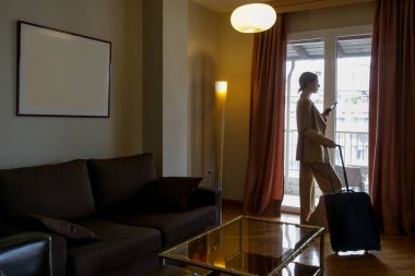 İş seyahati. Otel odasında çalışan genç bir iş kadını..