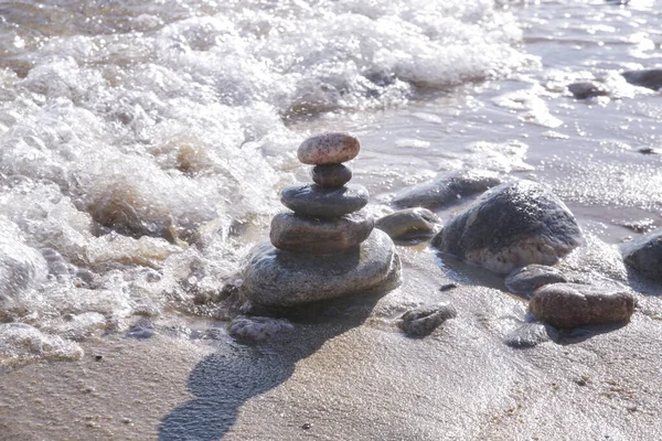 모래사장에 돌들의 피라미드와 물결치는 사이에서 균형을 으십시오 안정성 조화에 — 스톡 사진
