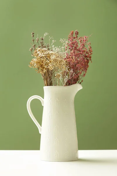 様々な乾燥した花や植物の束を持つセラミックジャグ — ストック写真
