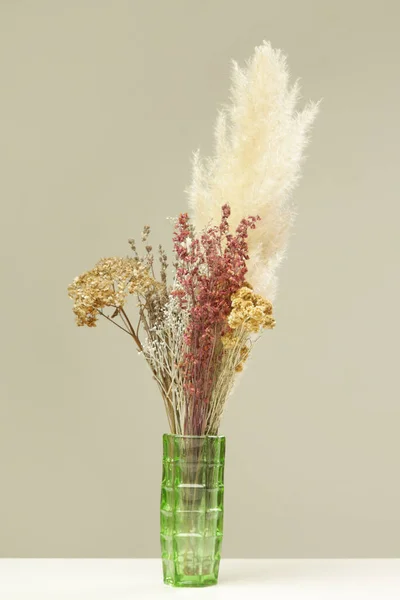 様々なドライフラワーや植物の束を持つ緑の花瓶 — ストック写真