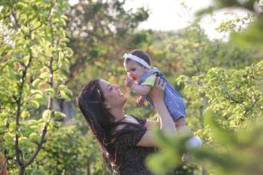  Genç anne, kızıyla dışarıda huzurlu bir yaz gününün tadını çıkarıyor. Parktaki aile fotoğrafı..