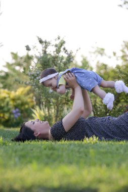  Genç anne, kızıyla dışarıda huzurlu bir yaz gününün tadını çıkarıyor. Parktaki aile fotoğrafı..
