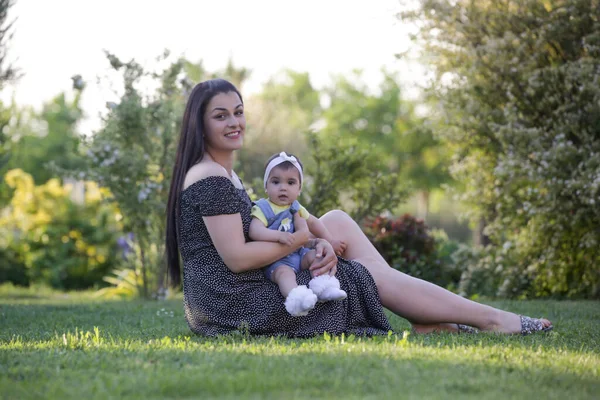  Genç anne, kızıyla dışarıda huzurlu bir yaz gününün tadını çıkarıyor. Parktaki aile fotoğrafı..