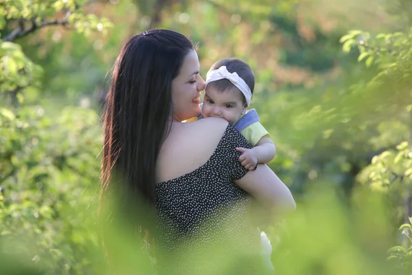  Genç anne, kızıyla dışarıda huzurlu bir yaz gününün tadını çıkarıyor. Parktaki aile fotoğrafı..