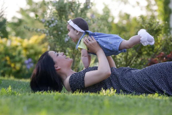  Genç anne, kızıyla dışarıda huzurlu bir yaz gününün tadını çıkarıyor. Parktaki aile fotoğrafı..