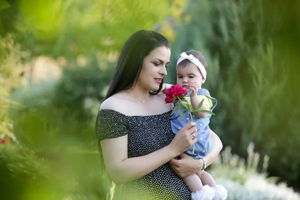  Genç anne, kızıyla dışarıda huzurlu bir yaz gününün tadını çıkarıyor. Parktaki aile fotoğrafı..