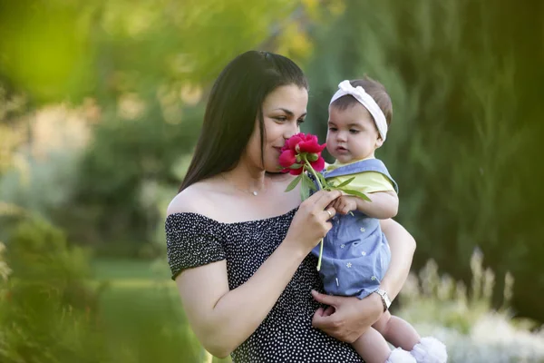  Genç anne, kızıyla dışarıda huzurlu bir yaz gününün tadını çıkarıyor. Parktaki aile fotoğrafı..