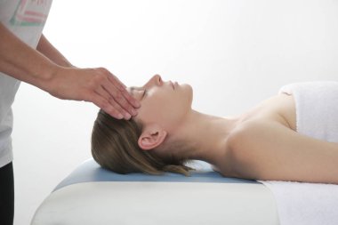 Yüz masajı. Kafkasyalı genç bir kadın kaplıcada kısmi rahatlama masaj deneyimi yaşıyor..