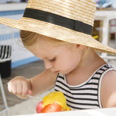 Beah Bar 'da dondurma kepçesi yiyen sevimli küçük kız. Yaz tatili konsepti.