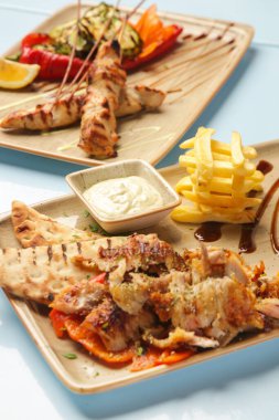 Restoran masasında Yunan usulü barbekü ve mezeler servis ediliyor