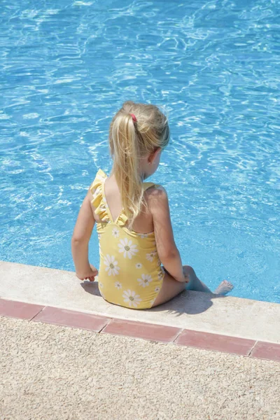 Sarı Mayolu Küçük Kız Havuzun Kenarında Oturuyor — Stok fotoğraf