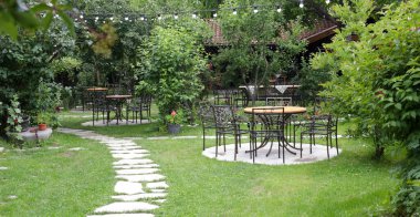 Güzel yeşil bahçedeki açık kafede masa hazır.