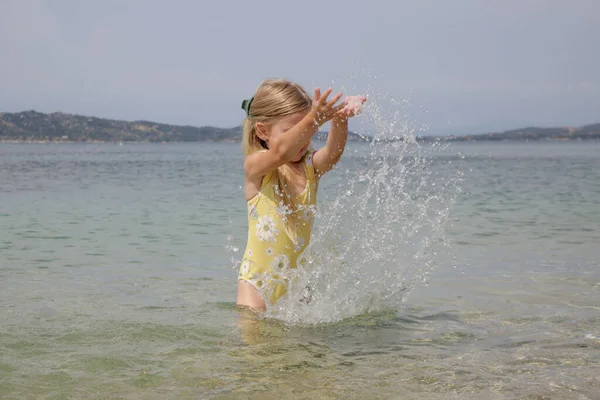 Adorable Toddler Girl Yellow Swimsuit Splashing Water Beach Idyllic Summer — Foto de Stock