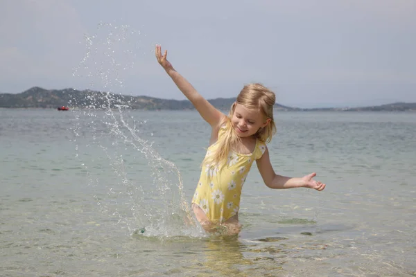 Adorable Toddler Girl Yellow Swimsuit Splashing Water Beach Idyllic Summer — Foto Stock