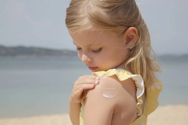 Carino Bambina Che Applica Crema Protettiva Sulla Spiaggia Lozione Solare — Foto Stock