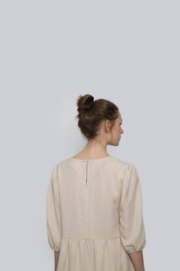 Serie of studio photos of young female model in casual beige midi dress