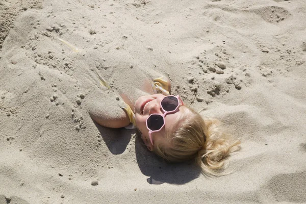 Cute Happy Little Girl Buried Sand Beach — стоковое фото