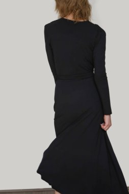 Serie of studio photos of young female model in black viscose wrap dress.