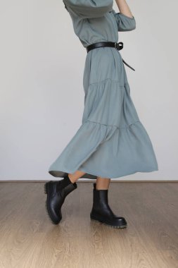 Serie of studio photos of young female model in casual gentle grey midi dress