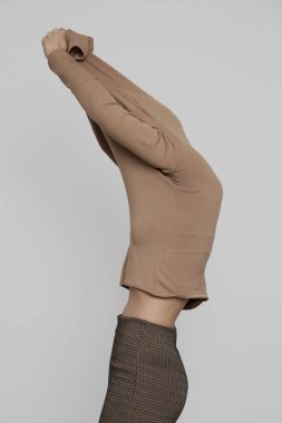 Serie of studio photos of young female model wearing beige turtleneck made from organic cotton. Comfortable sustainable fashion.