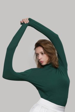 Serie of studio photos of young female model wearing all purple classic outfit, stretch viscose turtleneck and wide legged trousers.