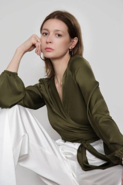 Serie of studio photos of young female model wearing pine green silk satin wrap blouse