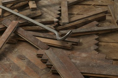 Home improvement. Removing old wooden parquet flooring using crowbar tool. Old wooden floor renovation.