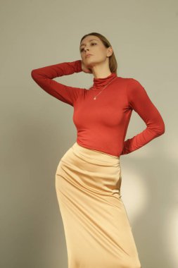 Serie of studio photos of young female model in slip dress and turtleneck. Casual edgy autumn winter outfit idea with silk satin slip dress. 