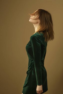 Serie of studio photos of young female model in emerald green plush mini dress, autumn winter fashion collection.
