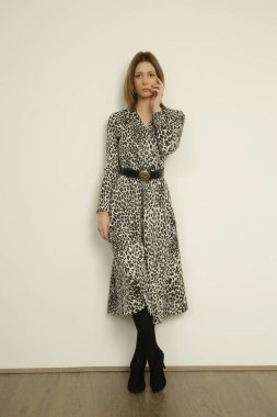 Serie of studio photos of young female model in animal print wrap dress, autumn winter fashion collection.