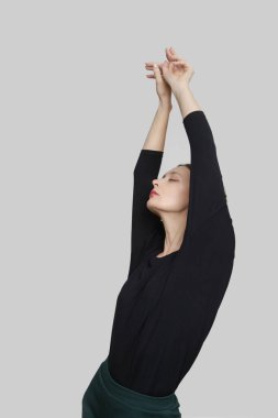 Stüdyoda, organik pamuktan yapılmış siyah gömlek giyen genç bir kadın modelin fotoğrafı. Rahat sürdürülebilir moda.