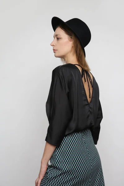 セリエのスタジオ写真の魅力的な若い女性モデル身に着けている黒ブラウスと幾何学的なプリントミディスカート — ストック写真