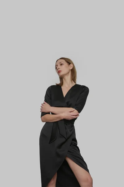 セリエのスタジオ写真の魅力的な若い女性を身に着けているエレガントな黒シルクサテンのドレス — ストック写真