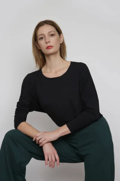 穿着简单舒适服装 有机棉衣和绿色长裤的年轻女模特的摄影棚照片系列 — 图库照片