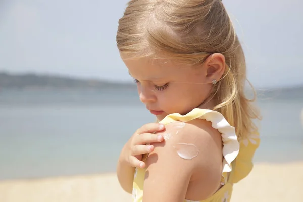 Carino Bambina Che Applica Crema Protettiva Sulla Spiaggia Lozione Solare — Foto Stock