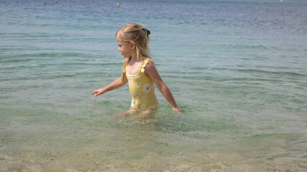 Adorable Toddler Girl Yellow Swimsuit Splashing Water Beach Idyllic Summer — стоковое фото