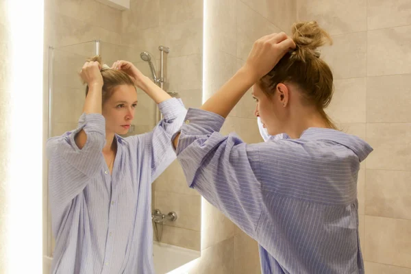 浴室のミラーの前で彼女の朝か夕方のルーチンをする若い女性 個人的な衛生および美の概念 — ストック写真